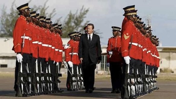 No sudden moves. I'm surrounded by black men with knives. Cameron tiptoes gingerly through honor guard on arriving in Jamaica.